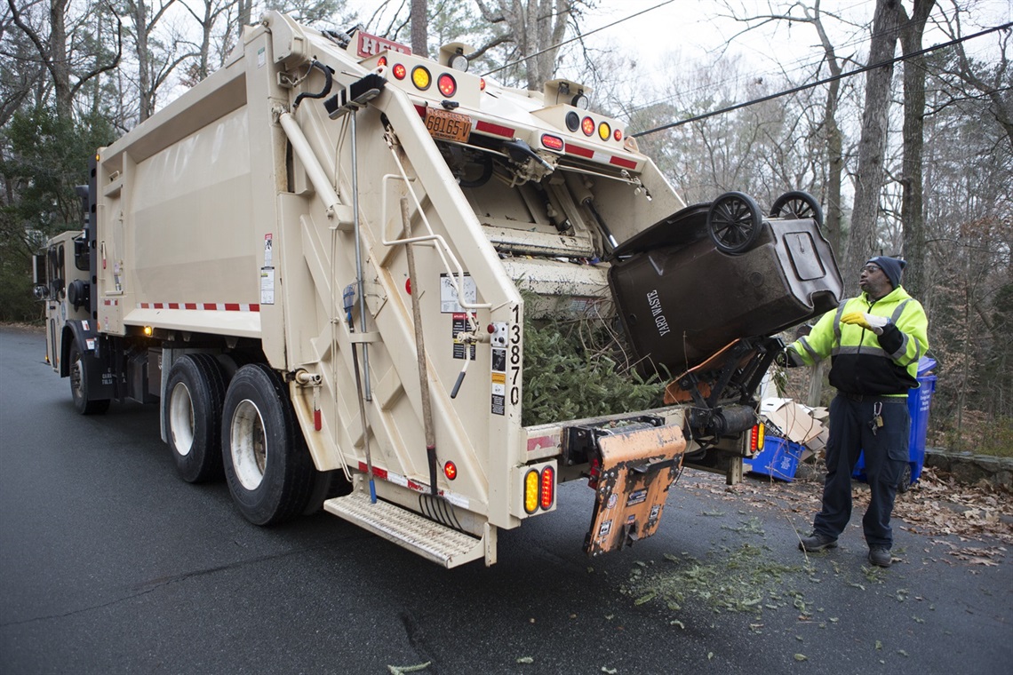 Solid Waste truck picking up yard waste.