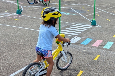 Girl on a bicycle riding through a traffic garden